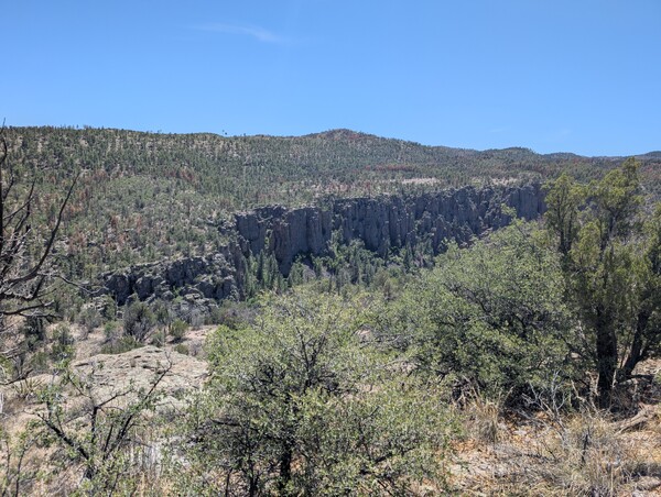 Views of mountains in the background, shrubs and sand in the foreground