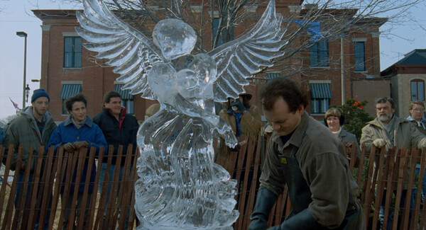 Phil carves an ice sculpture of an angel with a chainsaw